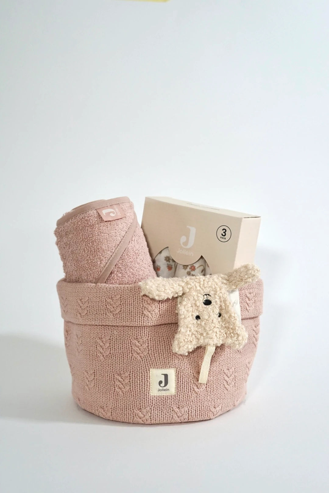 Eine geschenkbox für werdende eltern in rosa Style. Ein rosa Strick Pflegekorb mit einem rosa Kapuzenhandtuch aus Frottee Stoff, ein 3er Set Mulltücher (mit süßem schlichten Blumen Aufdruck) und ein Schmusetuch Teddy Bear.
