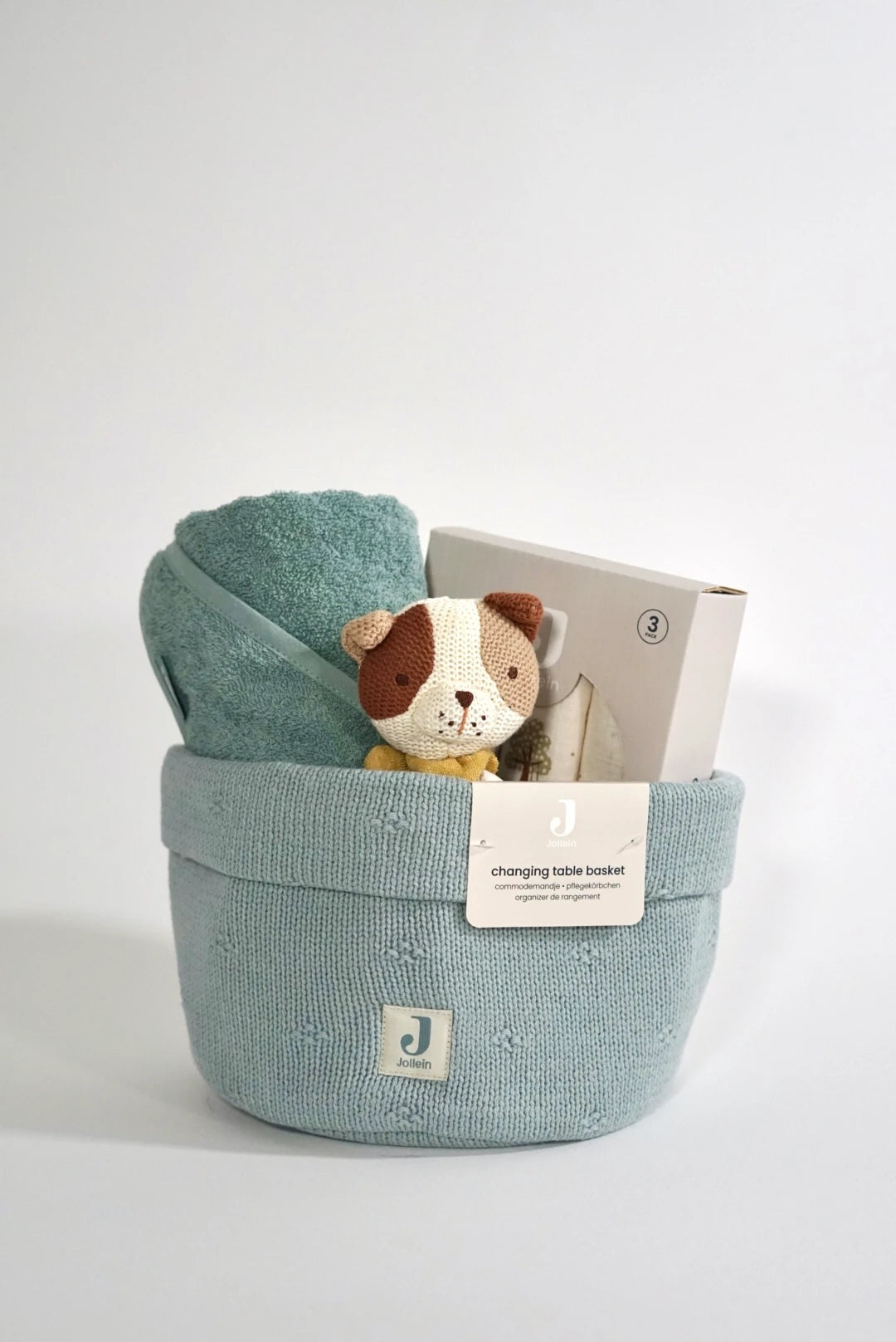 Eine schön Gestaltete Geschenkbox zur Geburt von swz-art mit Korb aus Strick in Blau, Kapuzenhandtuch aus Frotteestoff, Beißring aus Strick mit Hundmotiv und Mulltuch mit Tinypark Motiv.